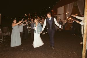 Dance party scene at a wedding reception with string lights and guests celebrating.