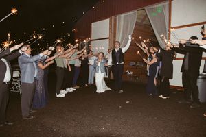 Reception guests dancing at a wedding celebration under festive string lights.