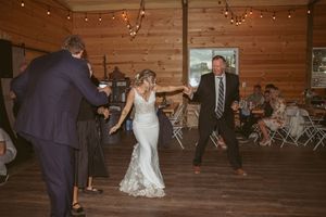 Couples dancing on wooden dance floor during evening wedding reception.