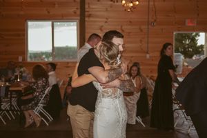 Wedding celebration in a wooden barn venue with elegant lighting and decor.