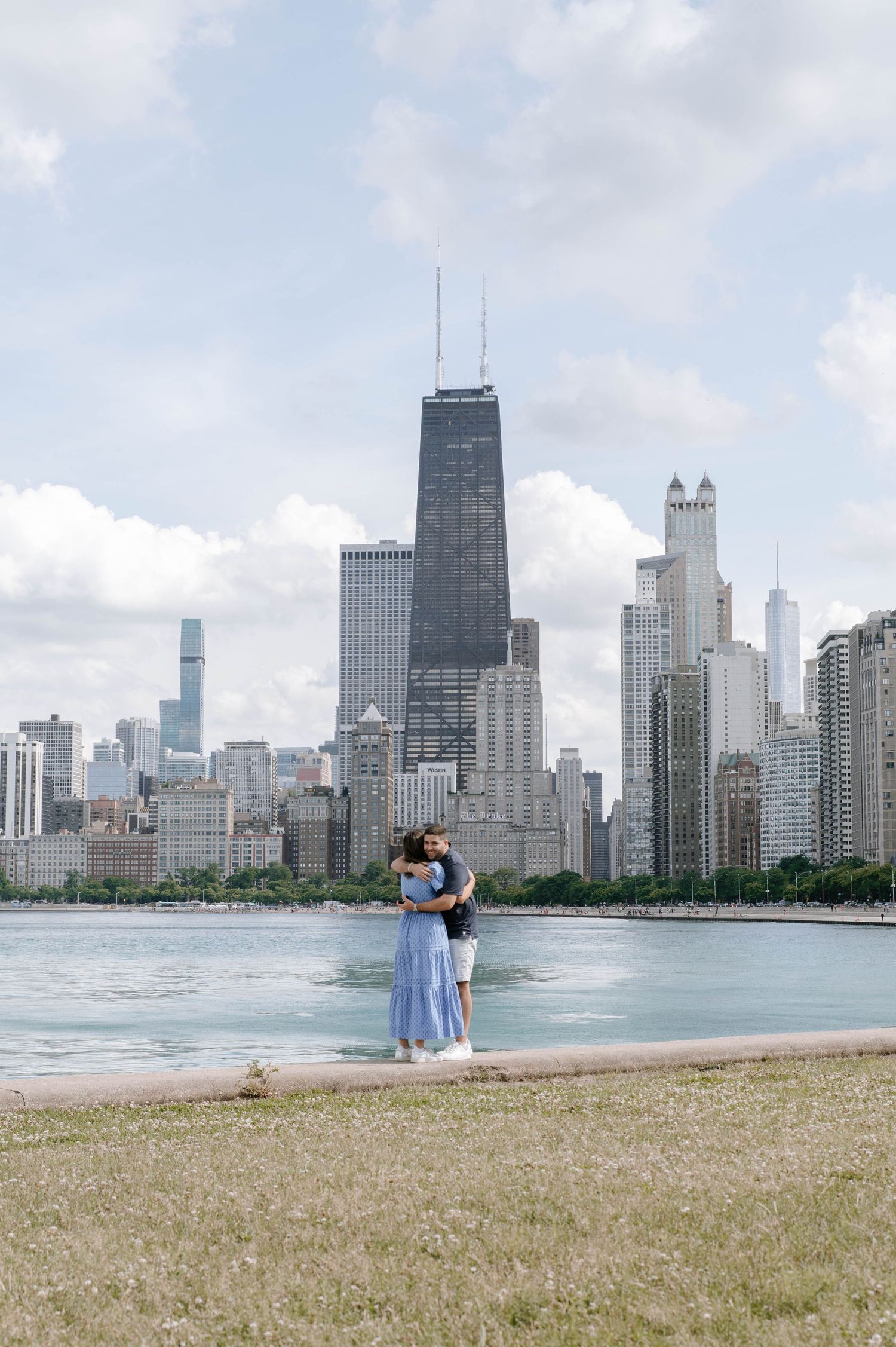 City skyline of Chicago with the iconic John Hancock building and other skyscrapers visible along the lakefront beach.