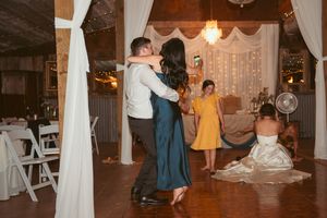 Wedding reception scenes showing guests dancing and celebrating in an elegantly decorated venue with white drapes.