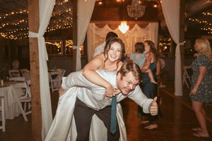 Joyful dance moves captured during wedding reception celebration under twinkling lights.