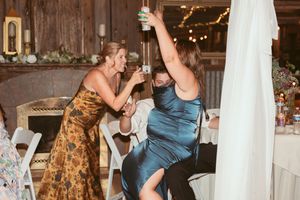 Wedding reception dance floor filled with celebratory guests in formal attire under warm lighting.