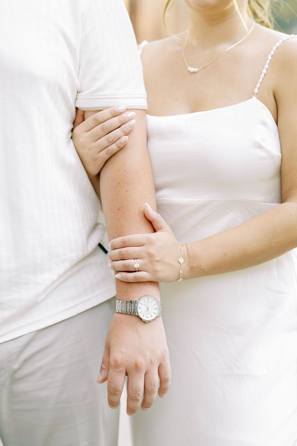 Three cropped images showing hands and arms wearing white clothing and jewelry in an intimate portrait style.