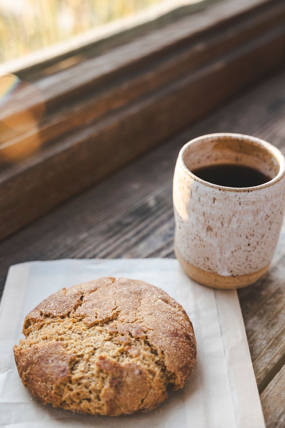 Freshly baked rustic sourdough bread loaves cooling on wooden surface with natural lighting.