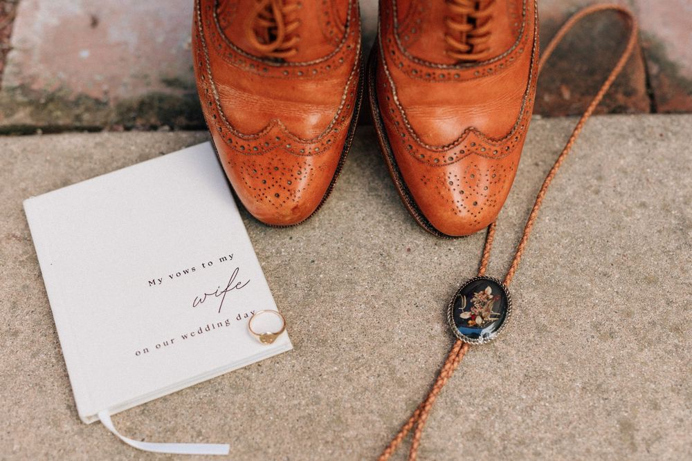 Bolero tie and groom's shoes and vow book