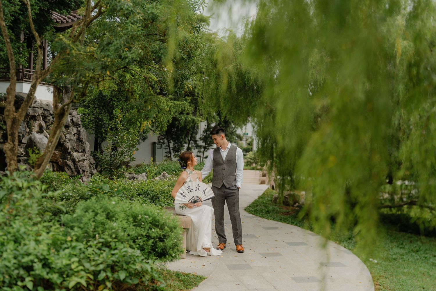 Garden wedding photography with willow trees and natural landscape elements.