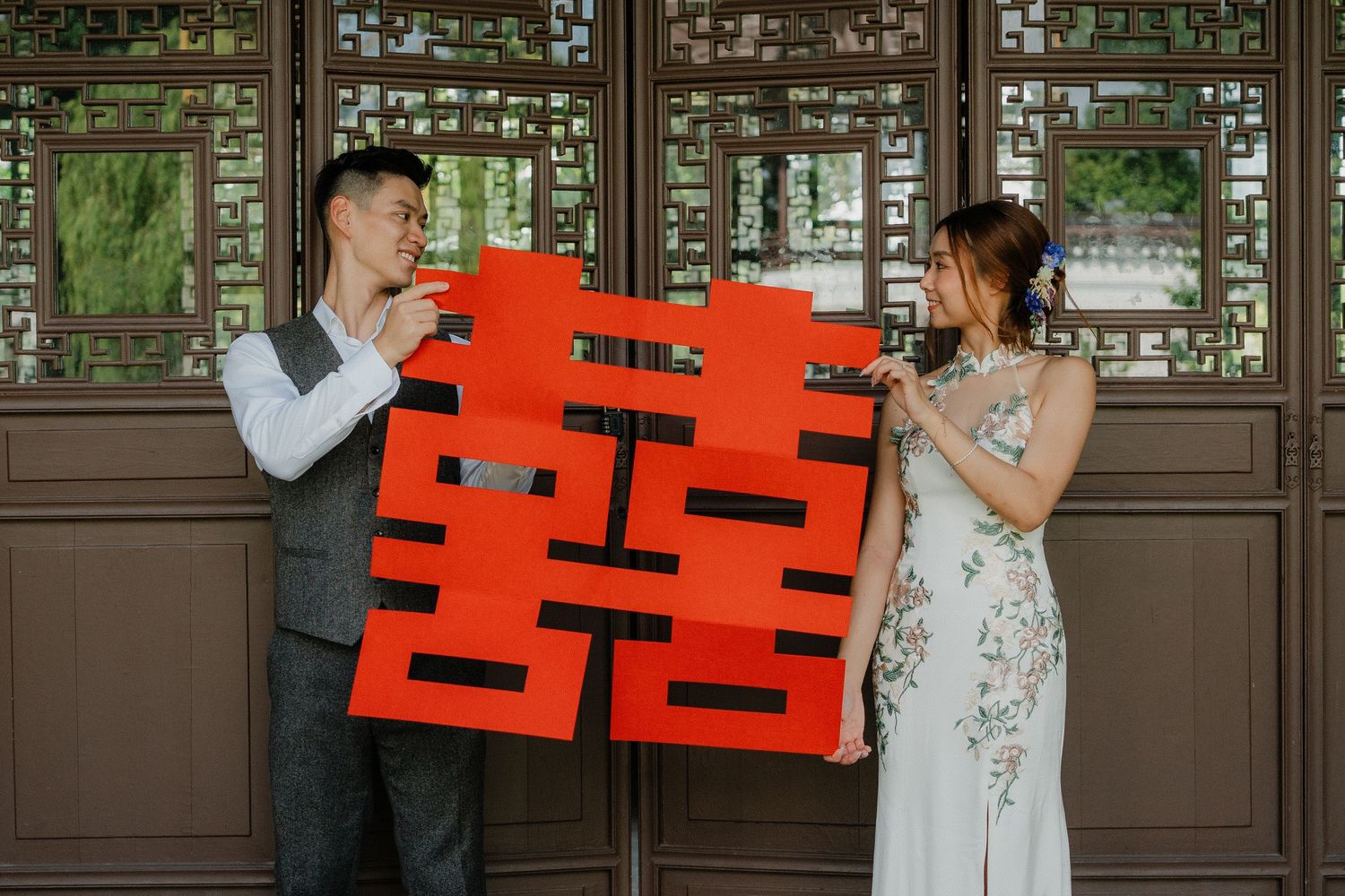 Red double happiness signs displayed against traditional wooden lattice panels.