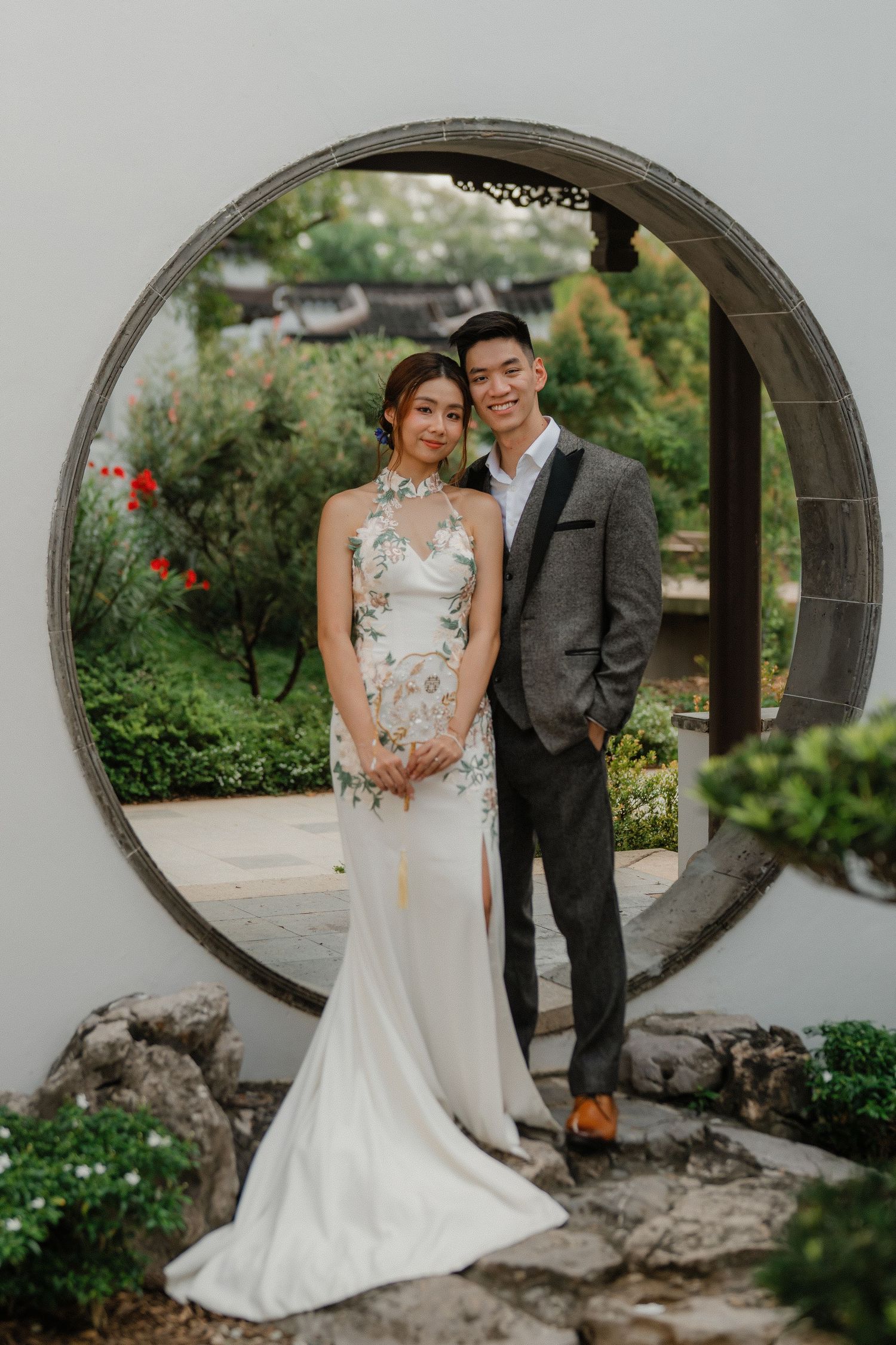 Decorative stone archways and garden paths create an elegant backdrop in a traditional Asian garden setting.