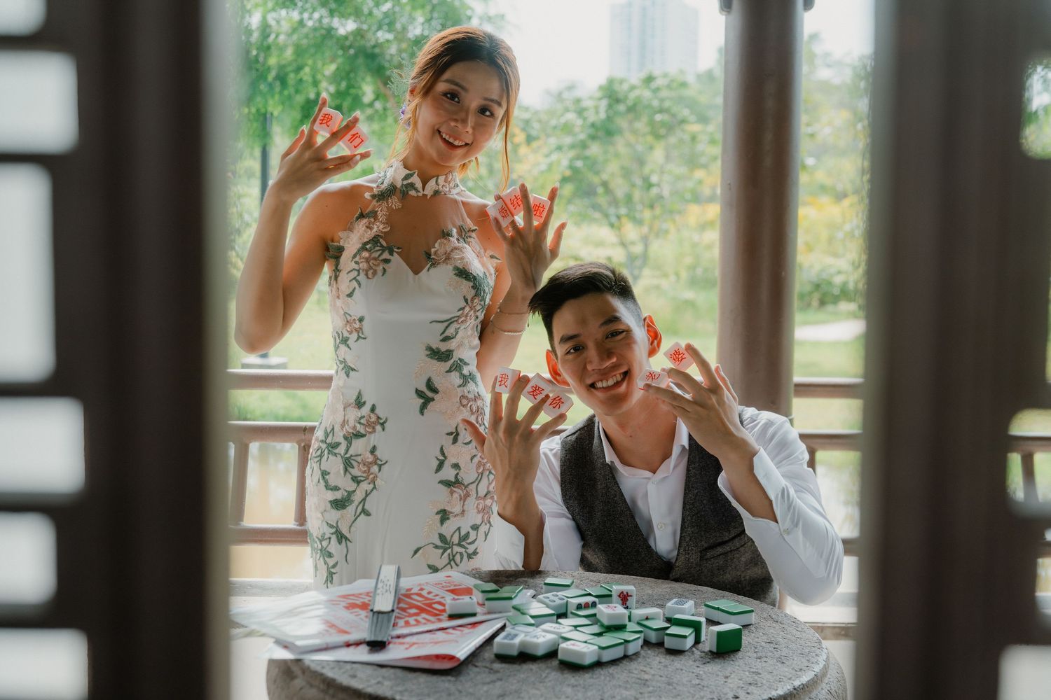 A playful moment captured of a couple making silly faces while playing cards in an elegant setting.