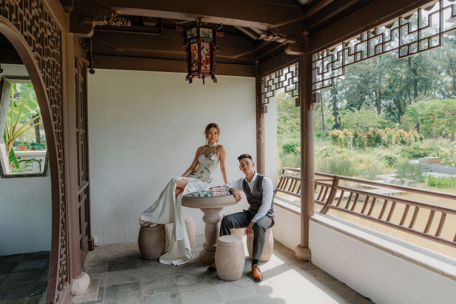 A romantic moment between a couple sitting together on a traditional Asian-style covered veranda overlooking nature.