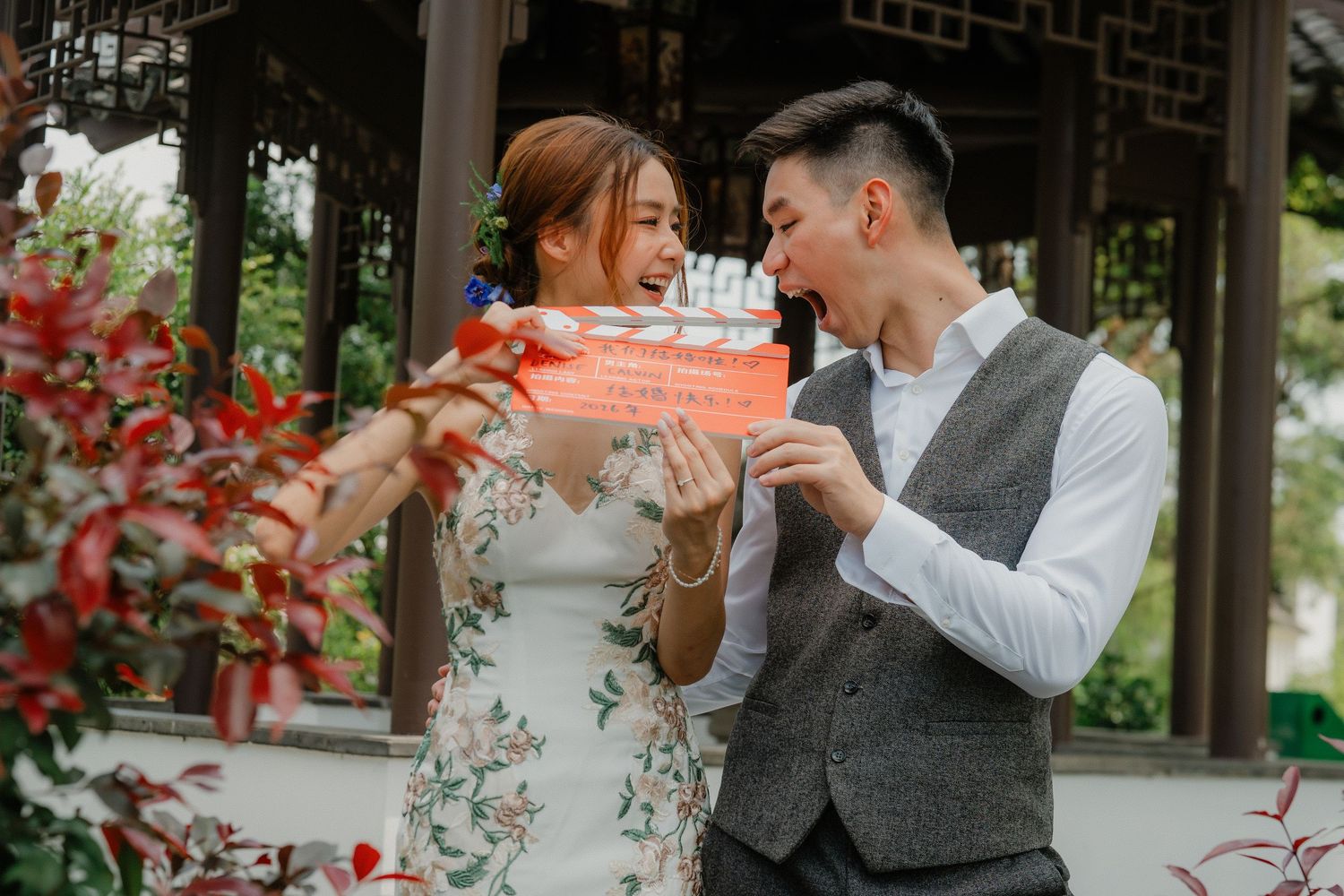 Couple enjoying tea ceremony in traditional Chinese garden setting.