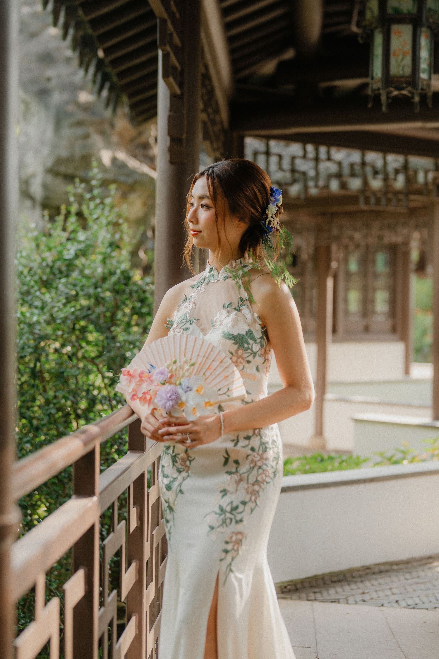 White wedding dress with lace details shown in multiple views along a traditional Asian covered walkway.