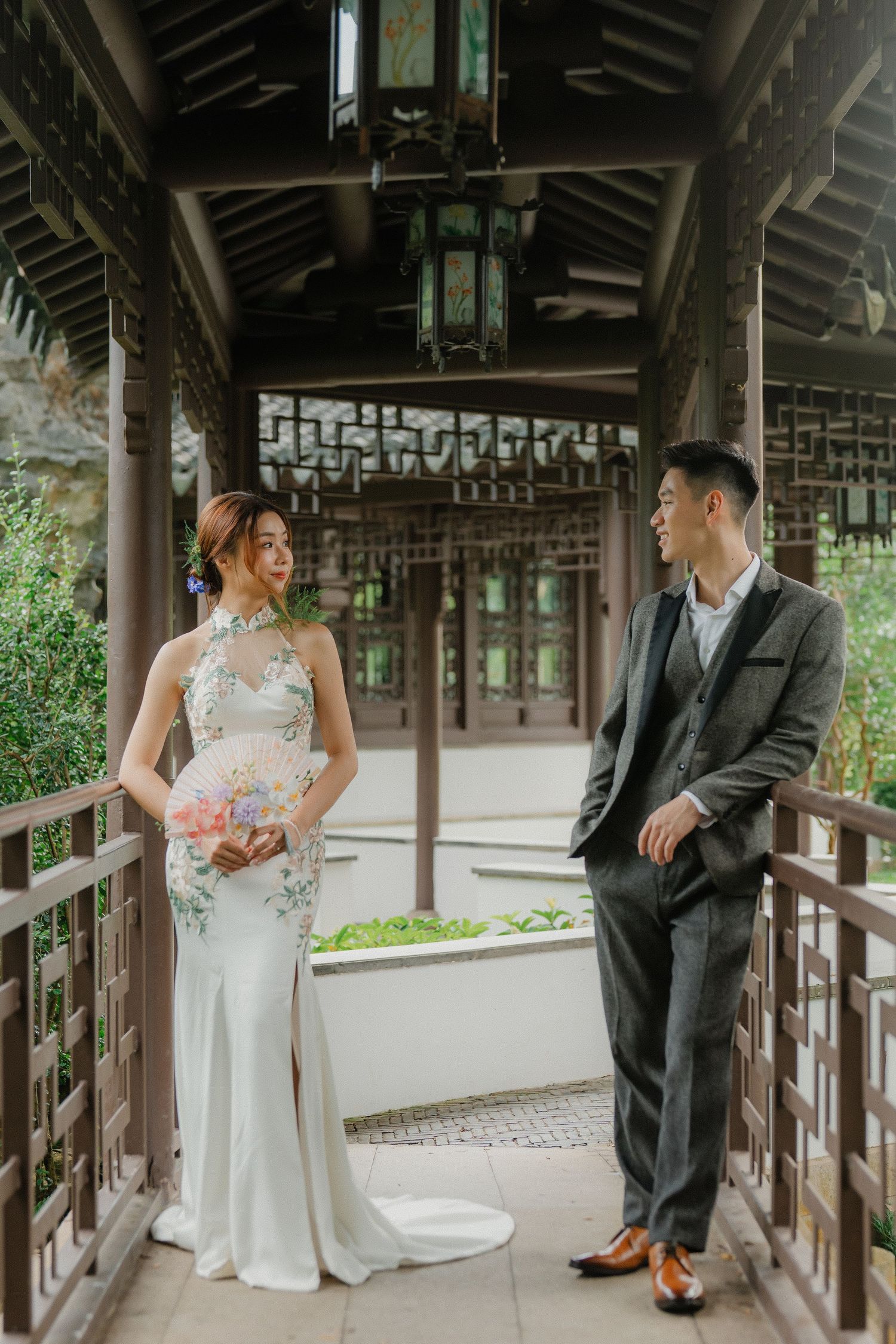 Wedding photos captured in traditional Chinese covered walkway with ornate architectural details.