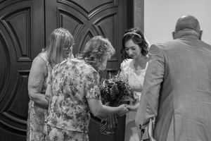 A group gathered in an indoor setting with dark wood panels and formal decor.