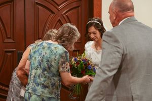 Family members and wedding participants greeting each other at a church altar.