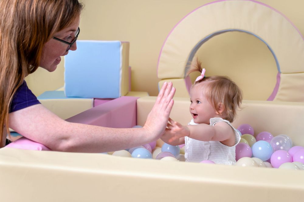 Interactive playtime moment with soft pastel-colored toys and decorative elements.