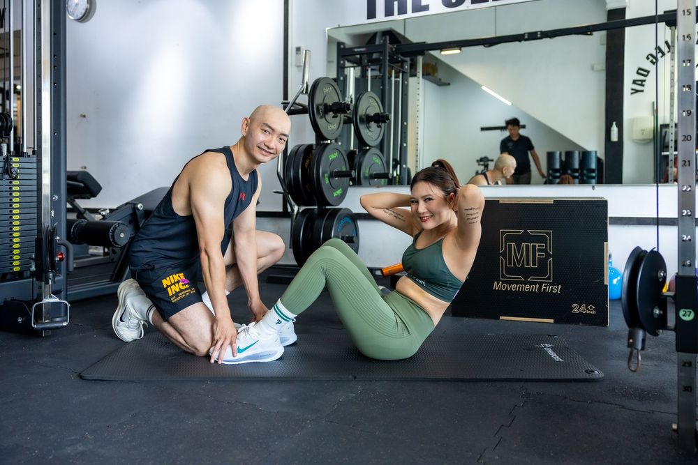 Person in activewear demonstrates proper form for cable machine leg kickback exercises at a gym.