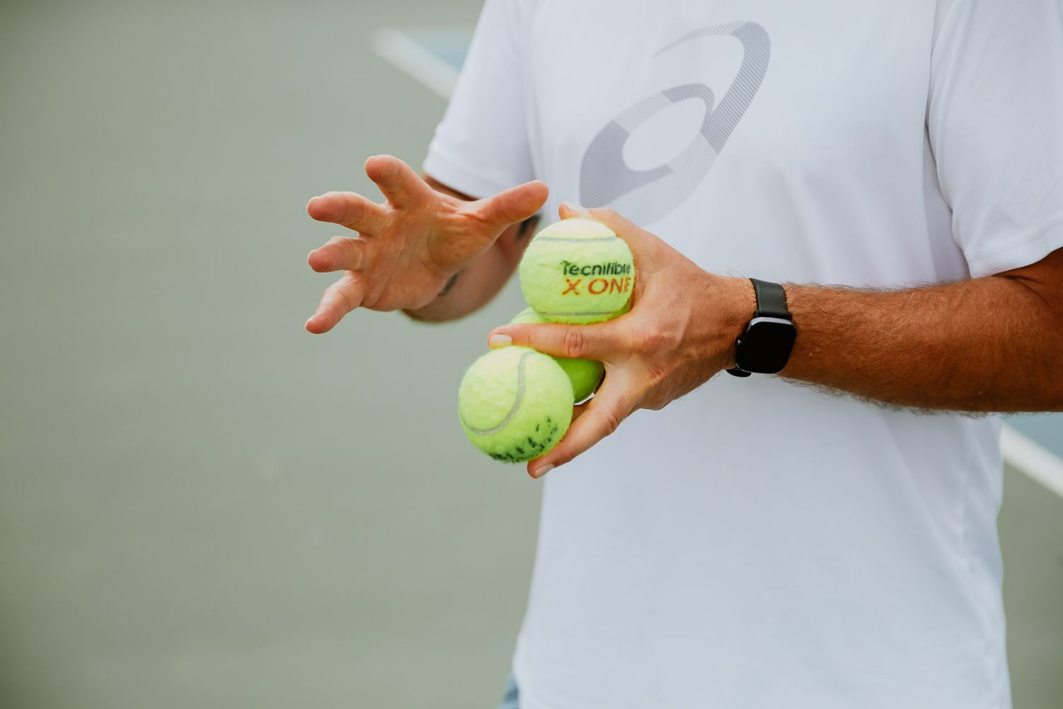 Hands holding two bright yellow tennis balls - CCTA Aix-en-Provence