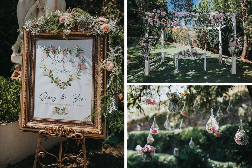 Elegant outdoor wedding decor featuring vintage framed signage and hanging glass orbs with delicate floral arrangements.