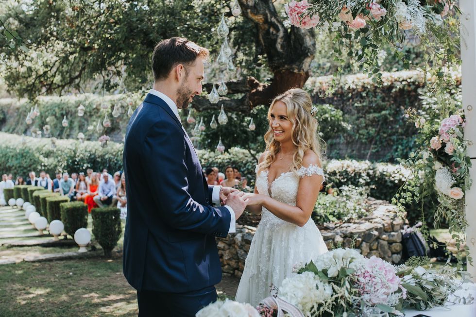 A romantic garden wedding ceremony moment with blooming flowers and decorative details in a lush outdoor setting.