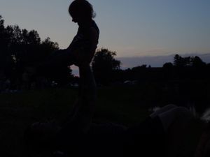 Silhouettes of people against a dusky evening sky.