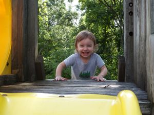 Yellow playground equipment with wooden frame captured during outdoor playtime.