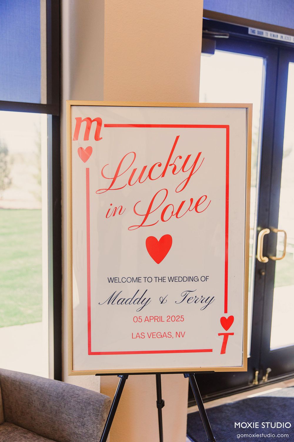 Wedding welcome sign reading 'Lucky in Love' with red heart displayed on easel at Las Vegas venue entrance.