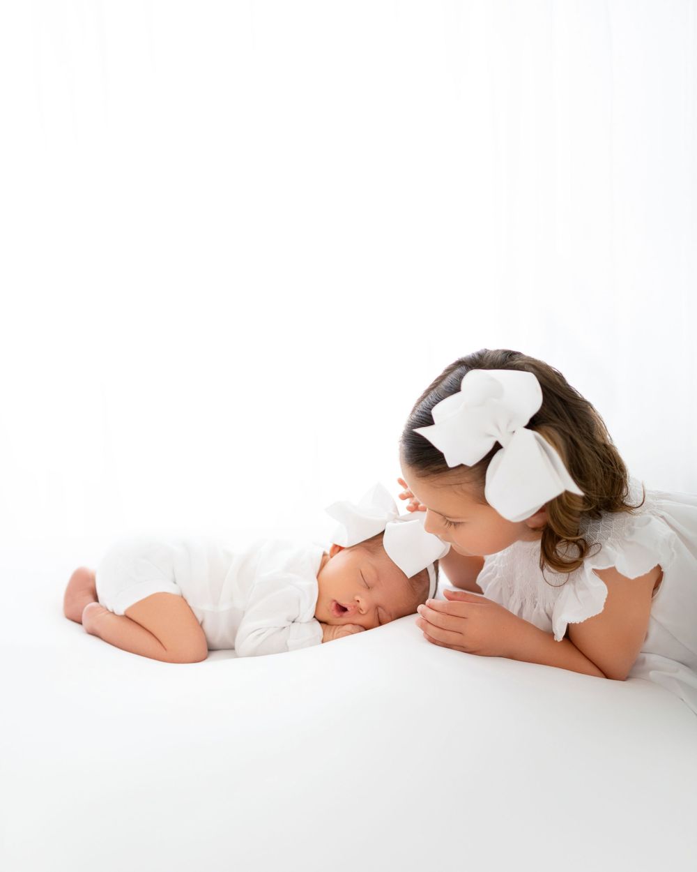 newborn baby girl photographed in Winchester VA studio with older sister by Beryl Photography