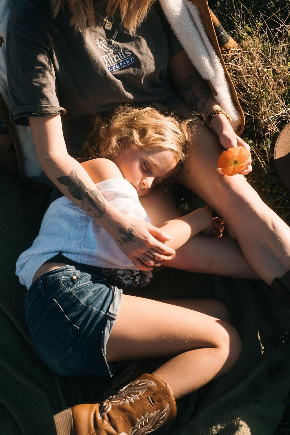 Sunlit scene of someone relaxing on dark blanket with brown leather boots.