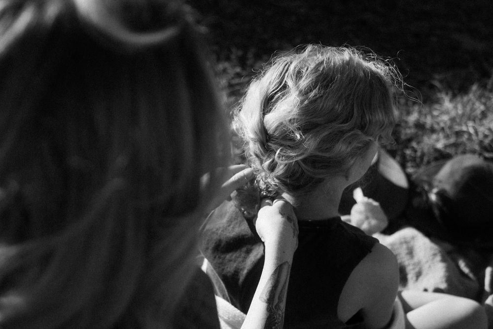 Candid black and white portrait showing curly hair illuminated by natural light.