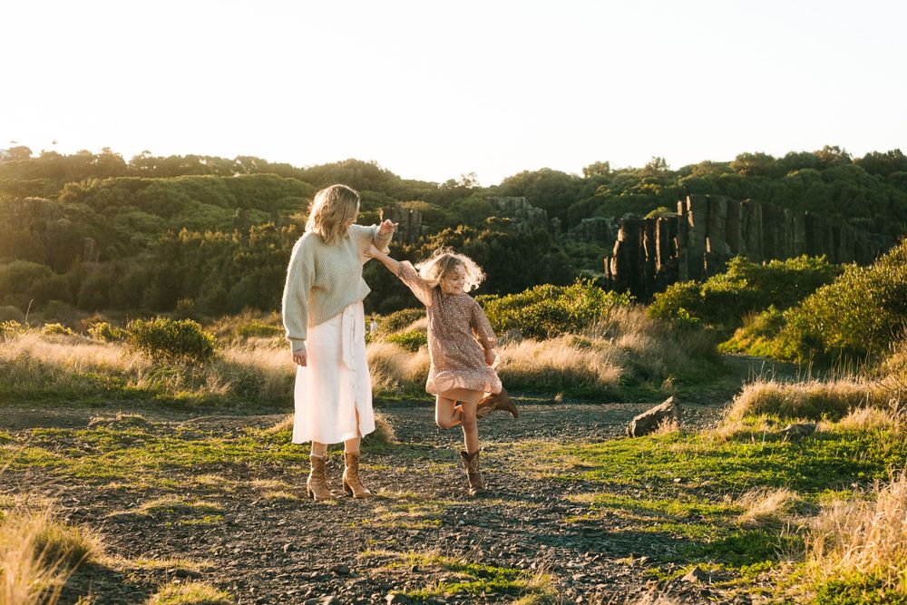 Two figures dance together joyfully on a hilltop path at golden hour.