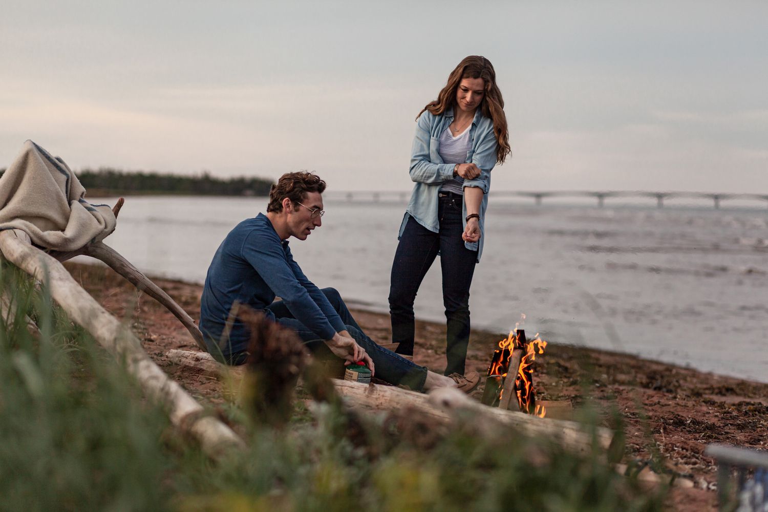 Couple preparing for a beach campfire during a cinematic storytelling photoshoot with Lumenali Photography. Chelton, PEI, Canada.