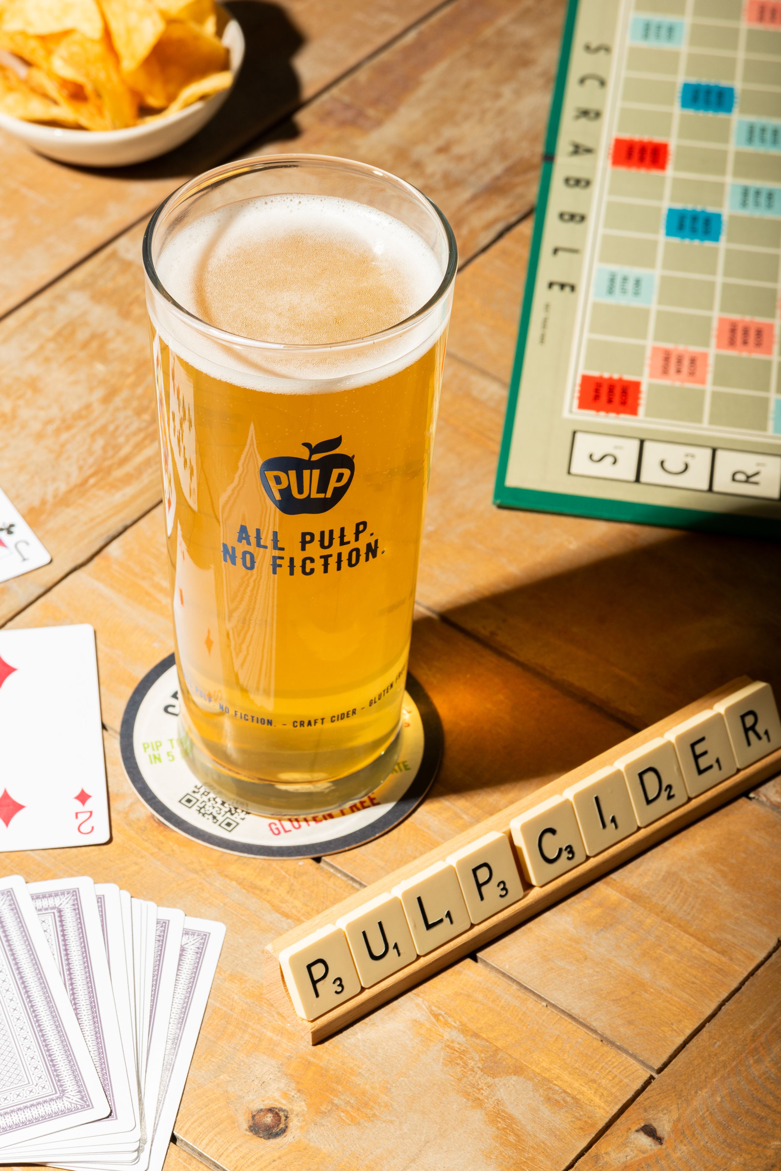 Lifestyle drink photography of PULP cider with scrabble tiles and games, styled for lifestyle moments, by a Worcestershire food photographer