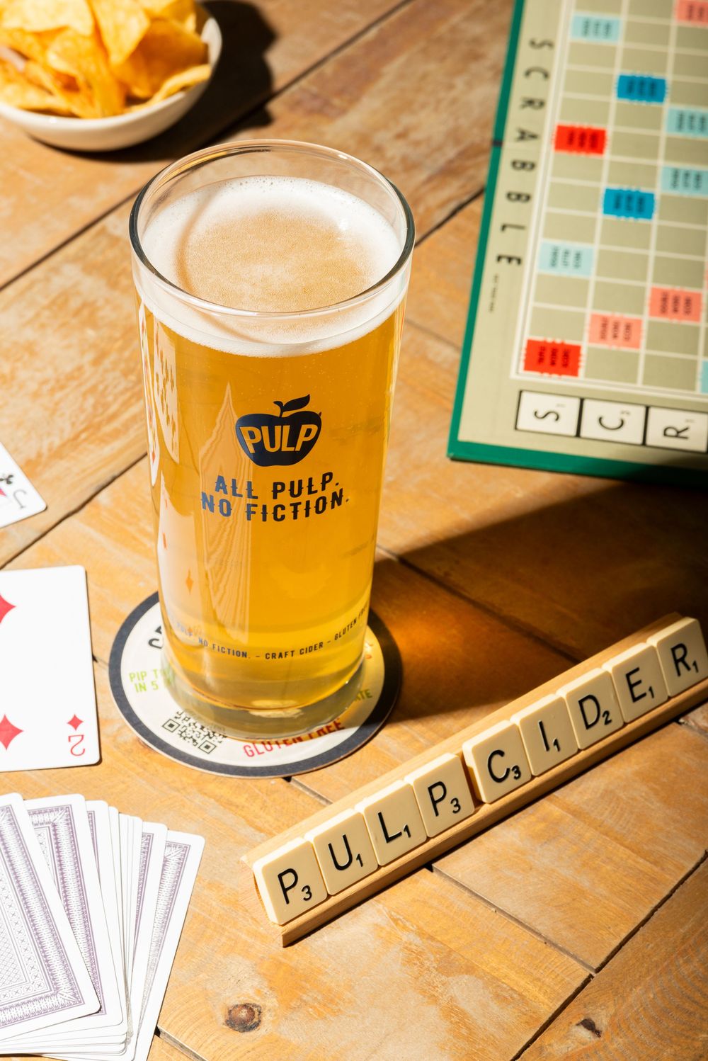 Lifestyle drink photography of PULP cider with scrabble tiles and games, styled for lifestyle moments, by a Worcestershire food photographer