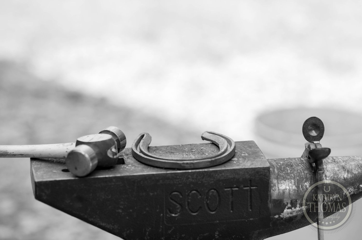 Black and white detail of tools resting on a Scott anvil surface.