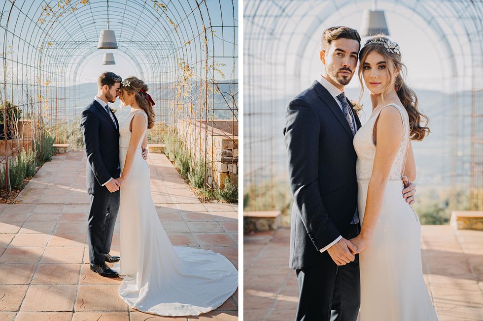 Elegant wedding couple embracing in a stunning glass greenhouse with city views in the background.