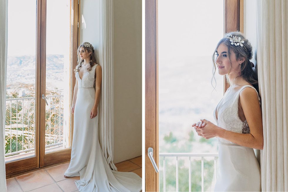 Elegant wedding dress and veil silhouetted against bright windows in a sunny bridal preparation room.