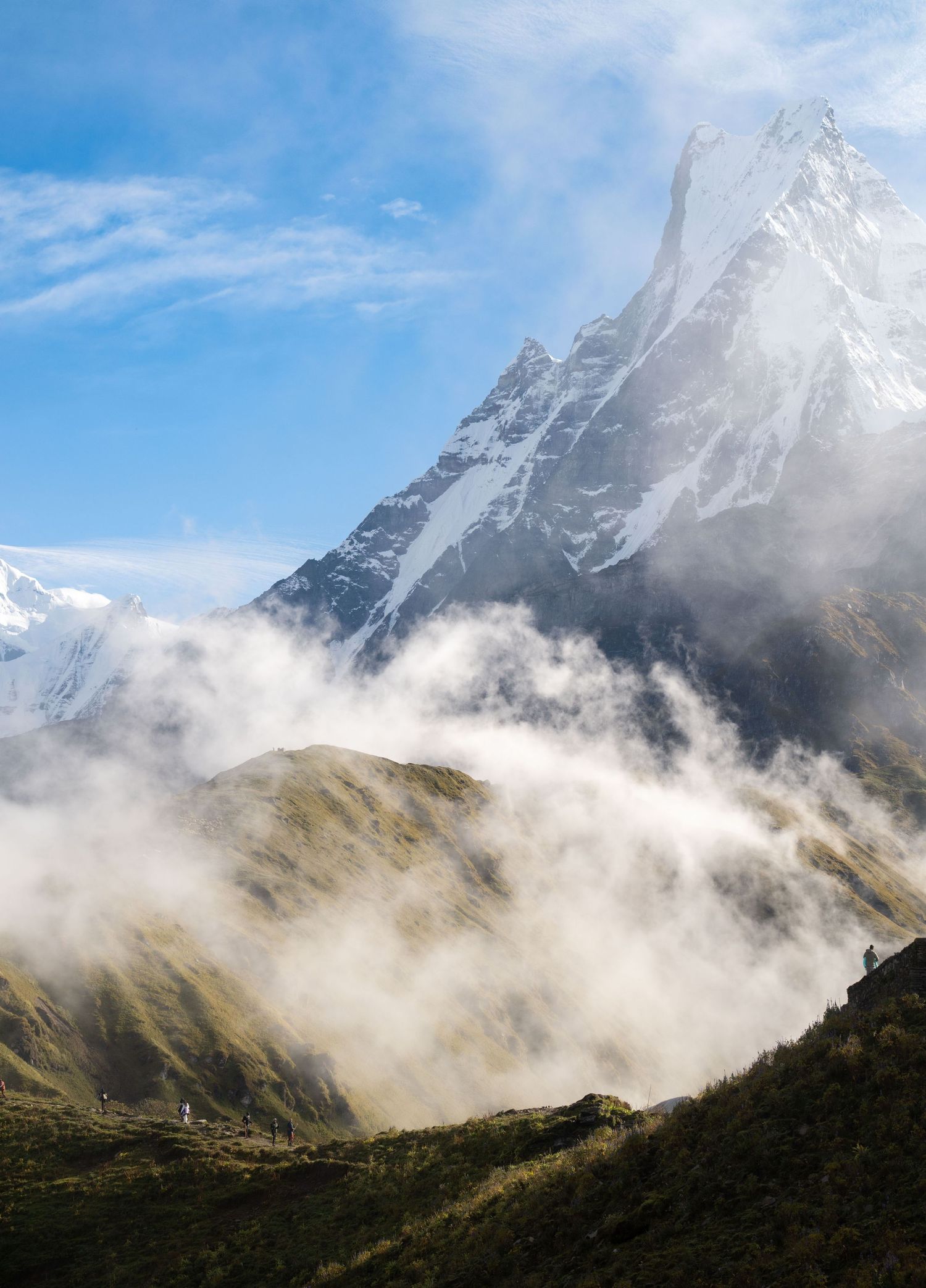 Dramatic mountain peaks shrouded in swirling clouds and mist during a moody morning in the mountains.