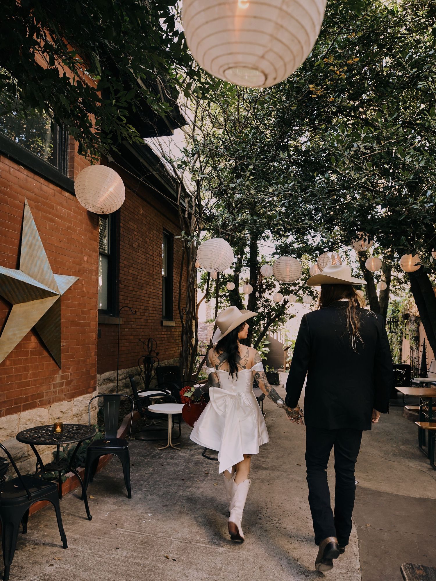 Outdoor walkway decorated with hanging paper lanterns and star decorations.