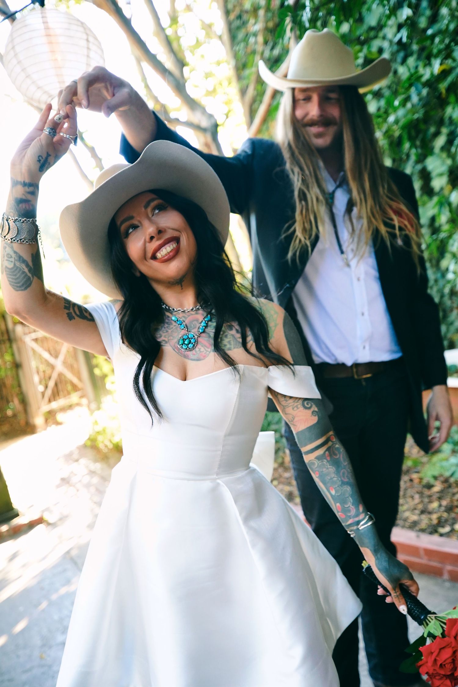 Outdoor wedding photoshoot featuring western-style outfits and cowboy hats.