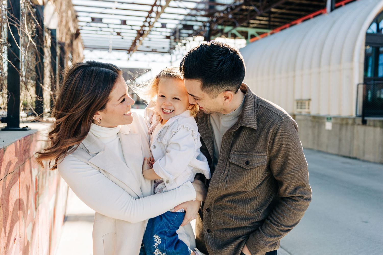 A family shares a moment together in an industrial setting with natural lighting in Charlotte, NC for family photos.