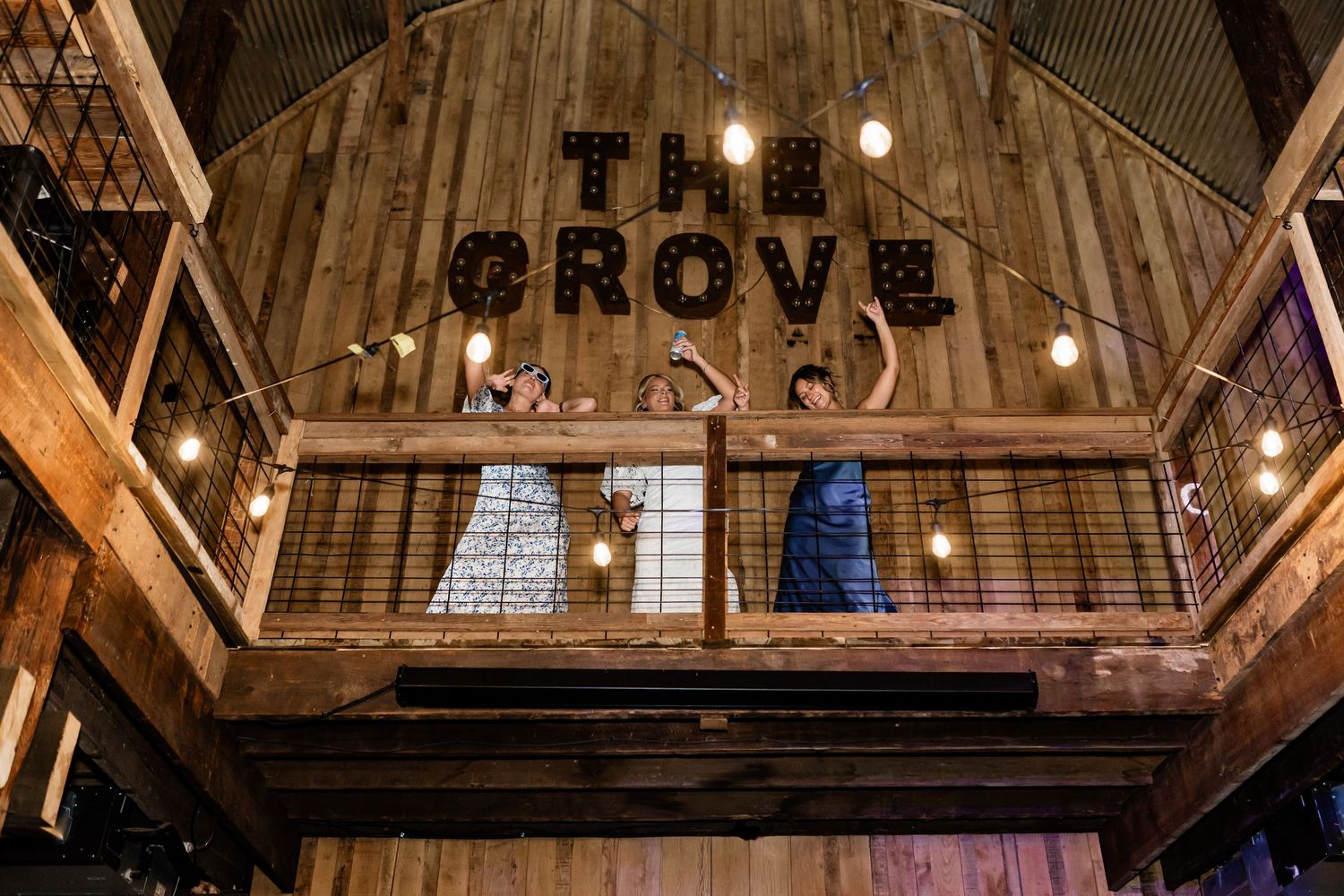 A bride and bridesmaids partying on the balcony in the barn at The Grove at Williamson Family Farm in Murfreesboro, Tennessee