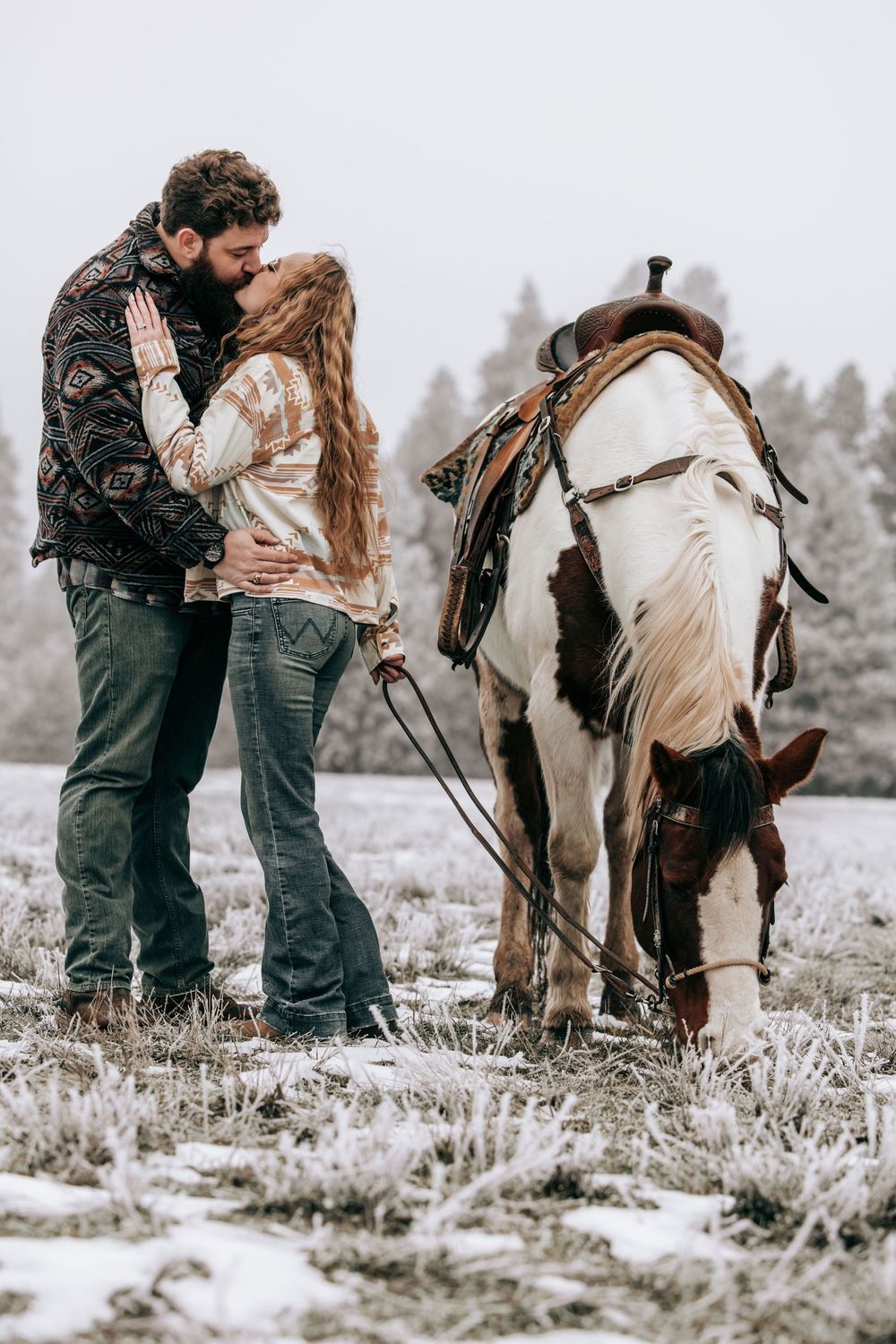 Cle Elum, WA Engagement session couple kissing with horse grazing nearby.