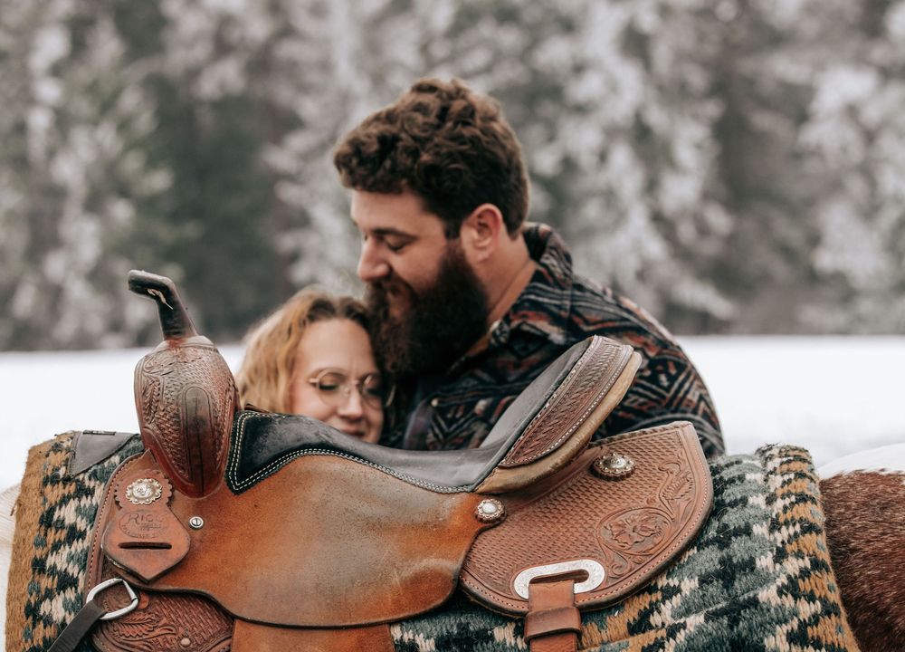 Cle Elum, WA Engagement session couple kissing with western saddle in view