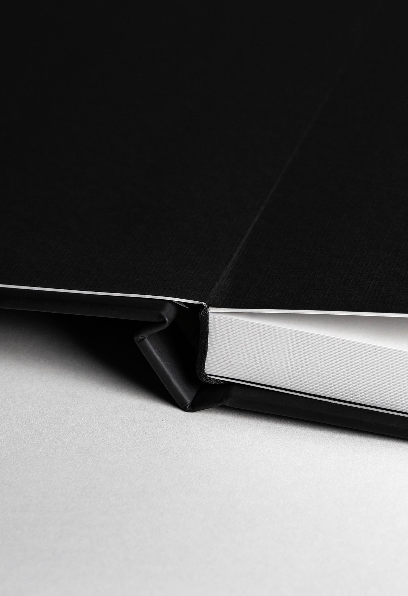 A black and white abstract photograph showing a sharp diagonal line dividing light and dark areas.