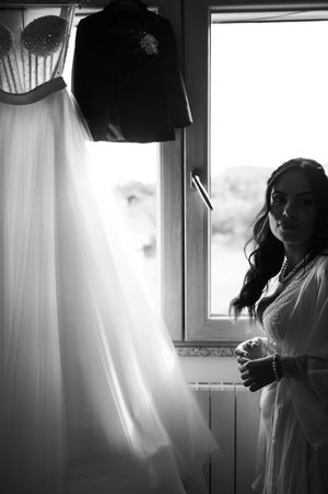 Black and white photo series showing silhouettes of a person in a wedding dress getting ready by a window.