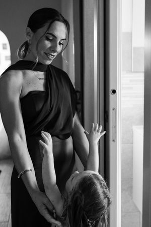 A series of black and white photographs showing tender moments between parent and child in an intimate home setting.