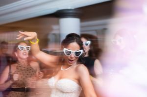 A sequence of blurry motion shots showing people dancing and celebrating at a party with sunglasses.